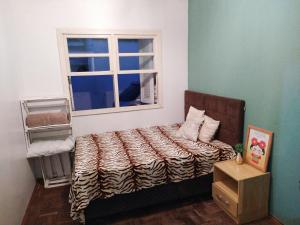 a bedroom with a bed and a window at Casa Yellow I Próxima a praça central in São Lourenço do Sul