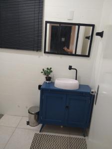 a bathroom with a blue sink and a mirror at Casa Yellow I Próxima a praça central in São Lourenço do Sul