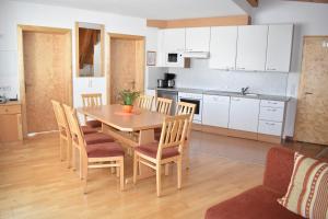 cocina y comedor con mesa de madera y sillas en Adamsberg, en Galtür