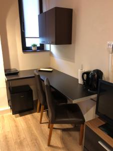 a kitchen with a black desk and chairs in a room at Casa Oliver in Braşov