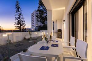 a white dining table and chairs on a balcony at Correeira Luxury Residence in Albufeira