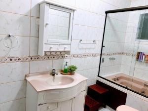 a white bathroom with a sink and a shower at Recanto dos Cafezais in Bueno Brandão +31 photos