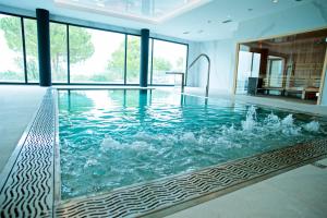 a large swimming pool with water in a house at Syncrosfera Fitness & Health Hotel Boutique in Pedreguer