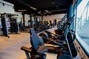 un gimnasio con filas de cintas de correr y máquinas en Syncrosfera Fitness & Health Hotel Boutique, en Pedreguer