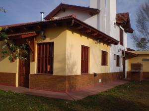 een huis met rode luiken aan de zijkant bij Complejo Foxes 2 in Villa del Dique