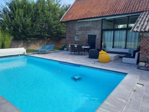 una piscina davanti a una casa di Aux p'tits bonheurs la grange a Neuve-Chapelle