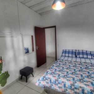 a bedroom with a bed and a chair and a door at Guest House Marinas in Angra dos Reis