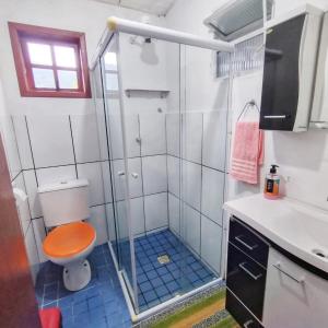a bathroom with a shower with a toilet and a sink at Guest House Marinas in Angra dos Reis
