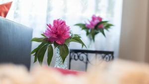 deux fleurs roses dans un vase sur une table dans l'établissement Haus Familie Presslauer-Mori, à Klopein am Klopeiner See