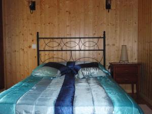 a bed in a bedroom with a wooden wall at Casa para vacaciones junto al Parque de la Naturaleza de Cabarceno in Obregón