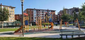 um parque infantil com escorregas e baloiços em Casa Lantoxana 1A121 em Gijón