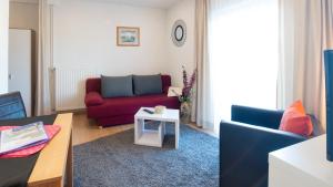 - un salon avec un canapé rouge et une table dans l'établissement Haus Familie Presslauer-Mori, à Klopein am Klopeiner See