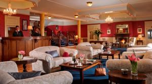 een grote woonkamer met banken en tafels bij Knockranny House Hotel & Spa in Westport