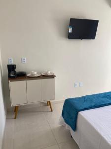 a room with a bed and a table with plates on it at Casa de Praia - Suítes in Arraial do Cabo