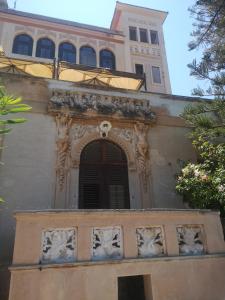 ein Gebäude mit einem Fenster und einem Uhrturm in der Unterkunft Relais dei Mori Home Palermo in Casteldaccia