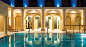 a large swimming pool with columns and a building at Knockranny House Hotel & Spa in Westport
