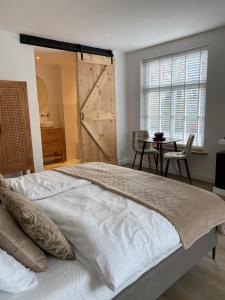 a bedroom with a large bed with a barn door at LOFT15 in Den Burg