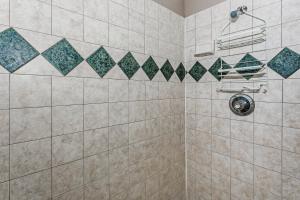 y baño con ducha y pared de azulejos. en Moreno Street Loft, en Pensacola 15 fotos más