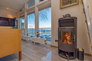a living room with a fireplace with a view of the water at fewo1846 - Residenz am Yachthafen - luxuriöses Strandhaus mit 2 Schlafzimmern in Flensburg