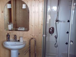 y baño con lavabo y ducha con espejo. en Casa para vacaciones junto al Parque de la Naturaleza de Cabarceno, en Obregón