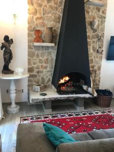 sala de estar con chimenea y pared de piedra en Colombella Apartment Agriturismo Collerisana, en Spoleto
