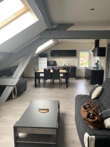 ein Wohnzimmer mit einem Sofa und einem Tisch in der Unterkunft Joli appartement Le tholy in Le Tholy