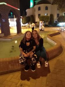 two women sitting next to each other in front of a fountain at Dima Popova Apartments in Tsarevo