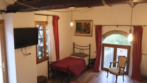 a bedroom with a bed and a tv and a window at B&B Il Pittore in Borgo San Lorenzo