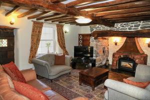 a living room with a couch and a fireplace at Panorama Cottages in Llangollen