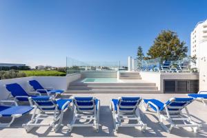 a group of blue chairs on the roof of a building at Correeira Luxury Residence in Albufeira