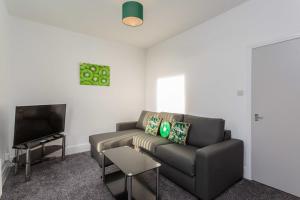 a living room with a couch and a flat screen tv at Cherry Property - Kiwi Suite in Blackpool