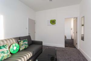 ein Wohnzimmer mit einem Sofa und einem Tisch in der Unterkunft Cherry Property - Kiwi Suite in Blackpool