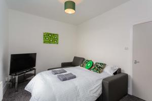 a bedroom with a bed and a flat screen tv at Cherry Property - Kiwi Suite in Blackpool