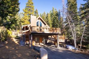 a house with a wrap around deck in the woods at North Shore - Cozy Cabin in Wood Vista