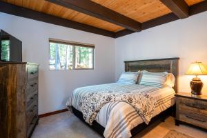 a bedroom with a bed and a dresser and a window at North Shore - Cozy Cabin in Wood Vista