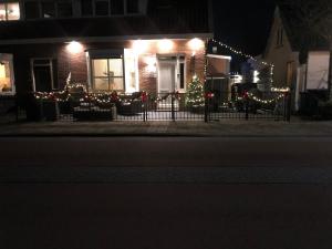 a house decorated with christmas lights and a christmas tree at gardenhouse mariposa in Badhoevedorp