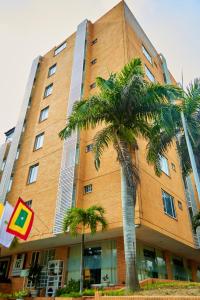 een groot gebouw met een palmboom ervoor bij Hotel Torre del Prado in Barranquilla