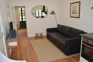 a living room with a black couch and a mirror at Casa Torta in Setúbal
