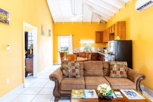 a living room with a couch and a kitchen at Chalk Sound Beach Residences Near Sapodilla Bay Beach by Angel Host in Providenciales