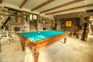 a pool table in the middle of a room at KERBELEG, ferme-manoir du XVè siècle, chambres grand confort in Riec-sur-Bélon +47 photos