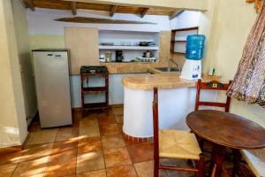 - une cuisine avec un comptoir, un réfrigérateur et une table dans l'établissement Casa Mexica Bungalows, à Zihuatanejo