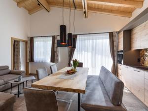 kuchnia i jadalnia z drewnianym stołem i krzesłami w obiekcie Ferienhaus zur Biene w mieście Söll