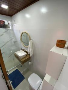 阿拉亚尔-杜卡布Suítes da Dri的浴室里有马桶、洗手池和镜子。