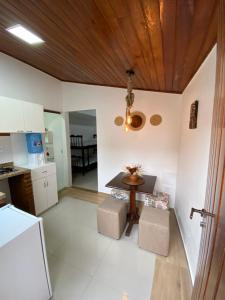 cocina con mesa y techo de madera en Suítes da Dri, en Arraial do Cabo