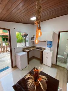 阿拉亚尔-杜卡布Suítes da Dri的带白色橱柜和桌子的厨房