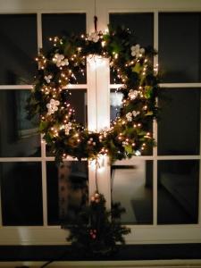 una corona di fiori con le luci di Natale alla finestra di L'Aubergine a Sprimont