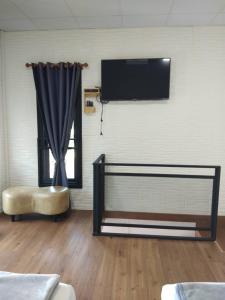 ein Wohnzimmer mit einem TV an der Wand und einem Stuhl in der Unterkunft บ้านขวัญกมล in Chiang Khan