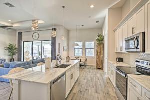 an open kitchen and living room with a blue couch at Sun-Seekers Getaway Lavish Cape Coral Villa in Cape Coral