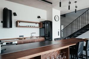 a kitchen with a counter with a sink and a staircase at GASS GOLF Penati in Šajdíkove Humence