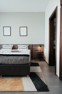 a bedroom with a bed and a rug at GASS GOLF Penati in Šajdíkove Humence